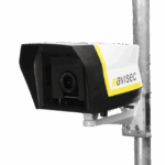 The avisec construction camera pro in the avisec outdoor housing mounted on a pole. The brand name "avisec" is written on the housing.