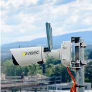 Avisec construction camera with antennas mounted on a pole above a construction site, used for wireless site monitoring or timelapse recording.